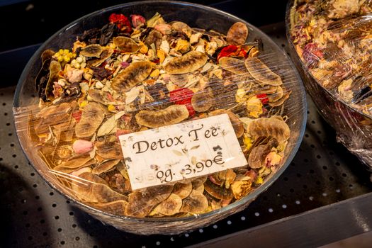 Bowl of detox herbal tea mix with various dried flowers and price tag.