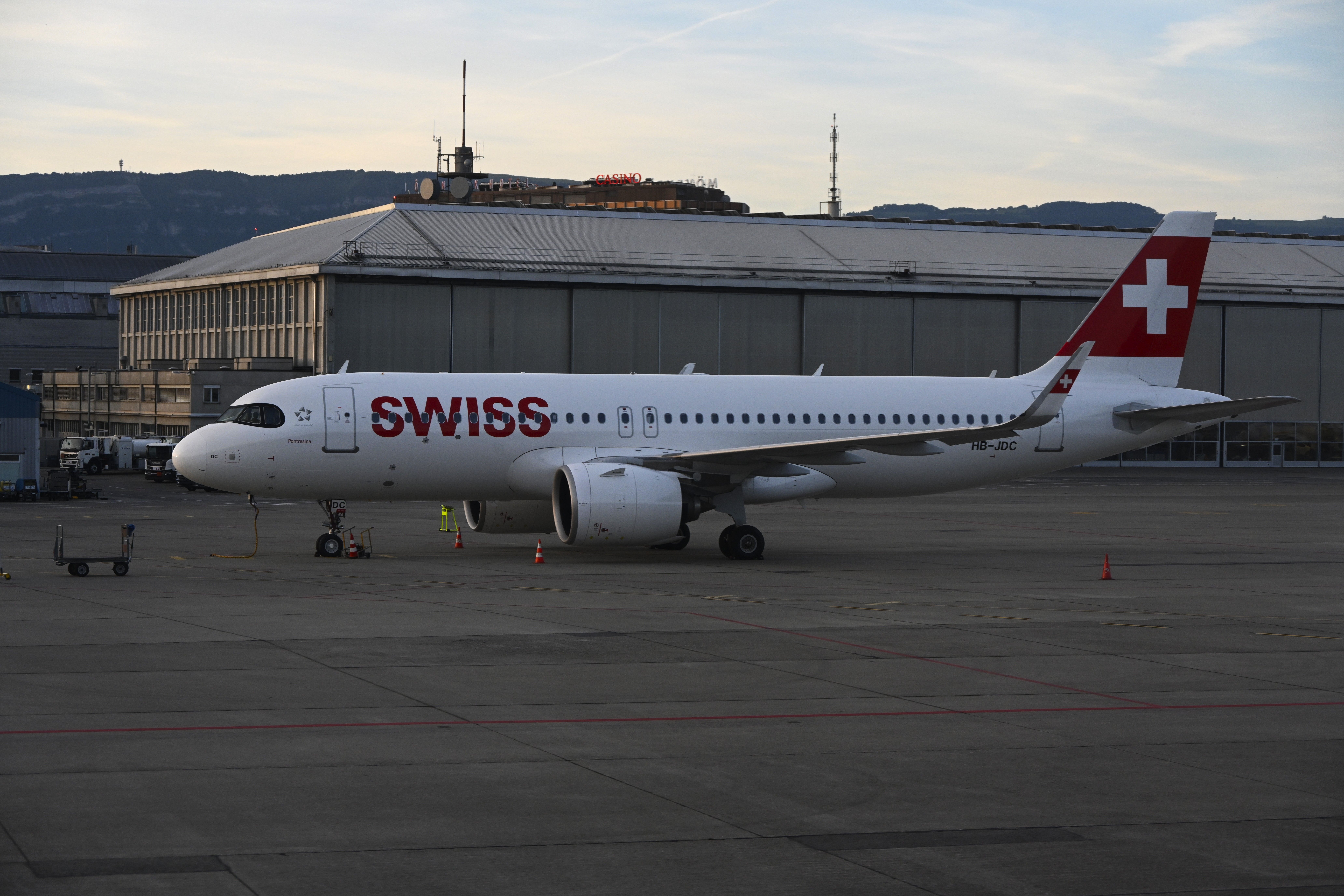 Swiss Airbus A320 at Genève Airport during sunset, showcasing Swiss aviation excellence.