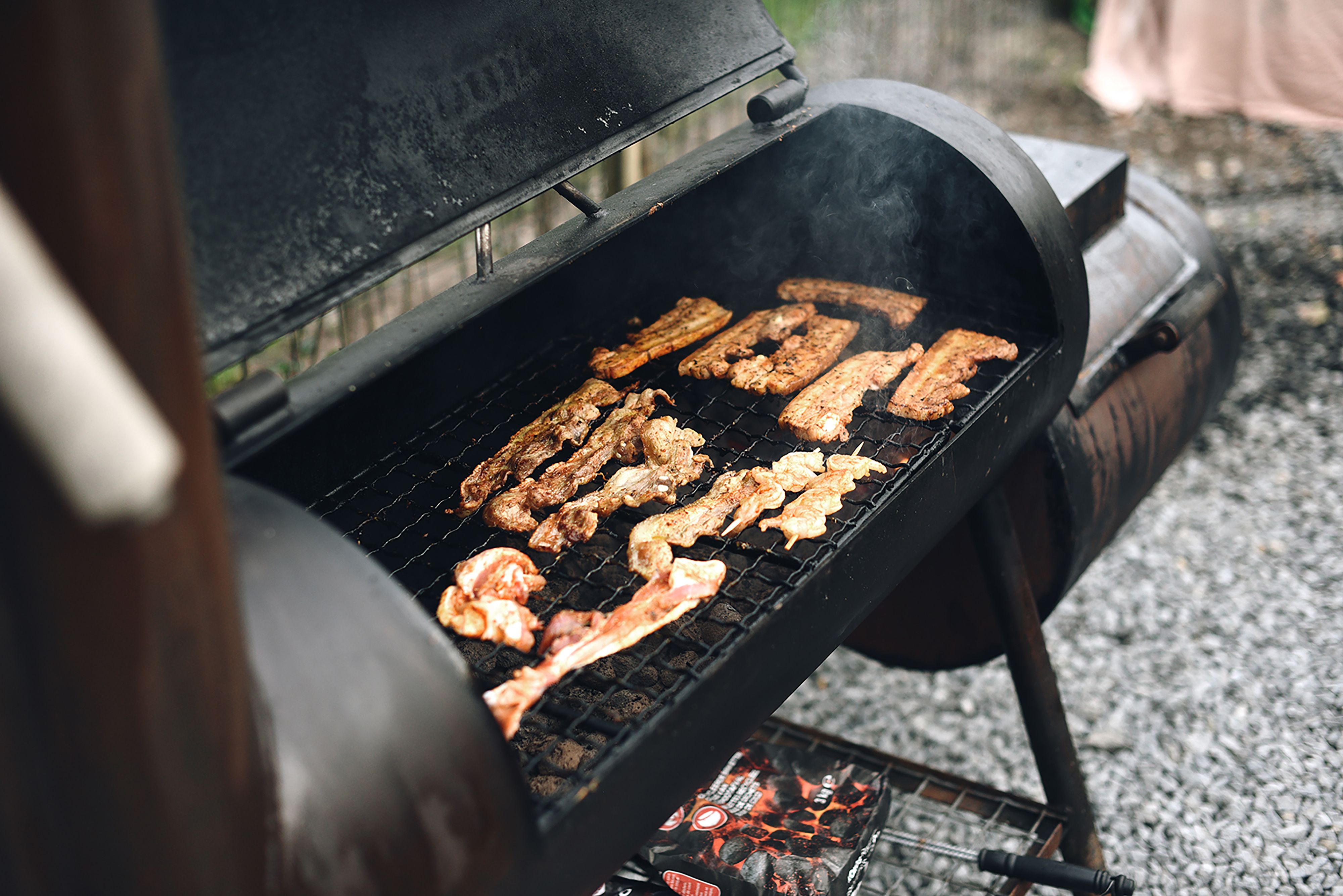Outdoor smoker with meat cooking over smoke