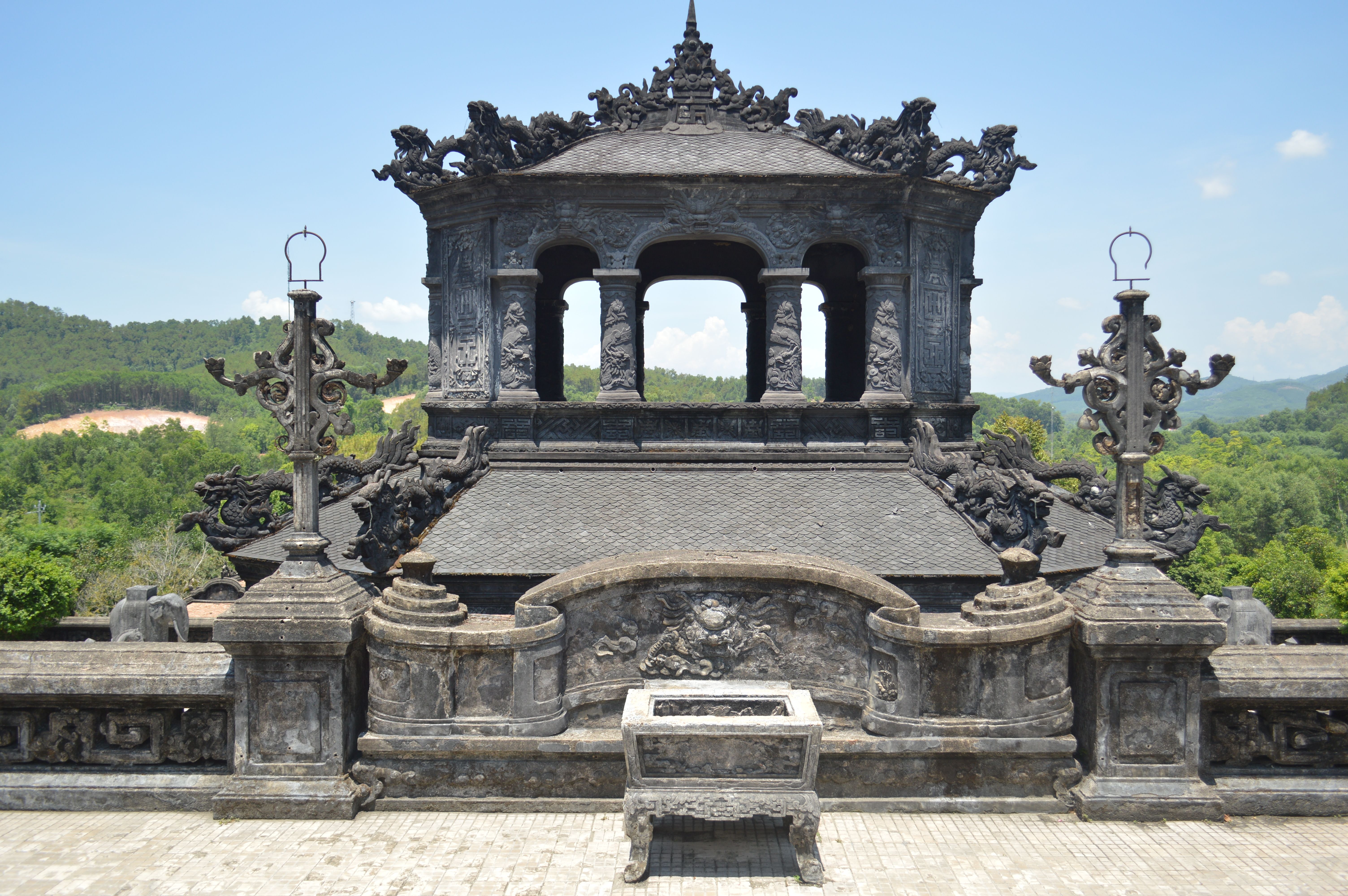 A traditional dragon kiln nestled in green hills, with smoke rising from its chimney