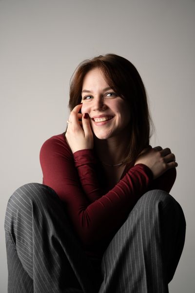 Woman in a cozy red sweater against a neutral background — photo by Mahyaddin Jabbarli on Pexels