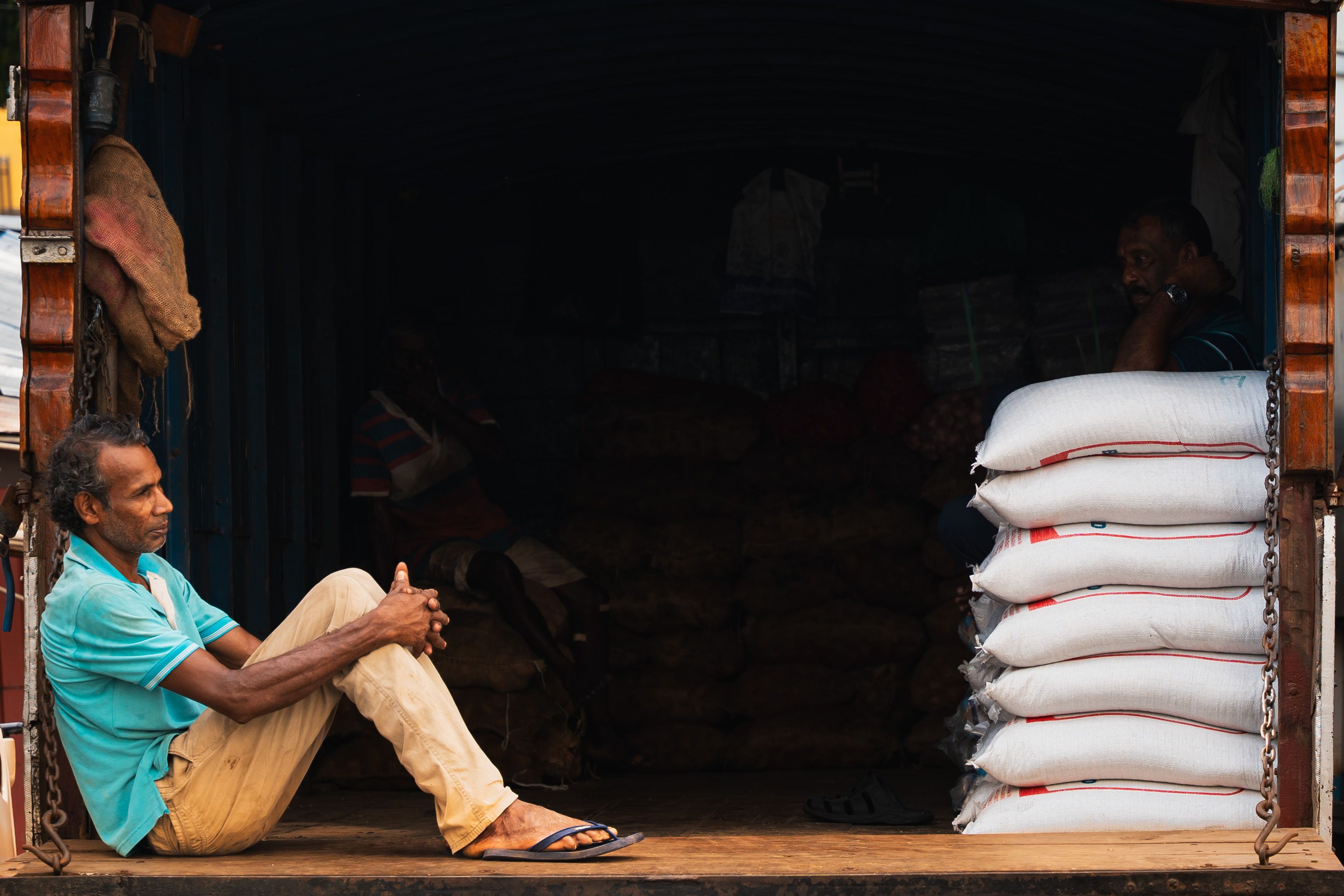 A street vendor in Pettah, Colombo, takes a moment of rest by his goods, depicting the daily life in Sri Lanka.