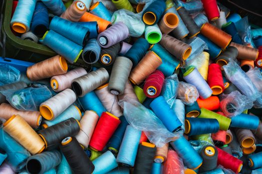 Vibrant collection of sewing thread spools in a Colombo market, showcasing street market life.