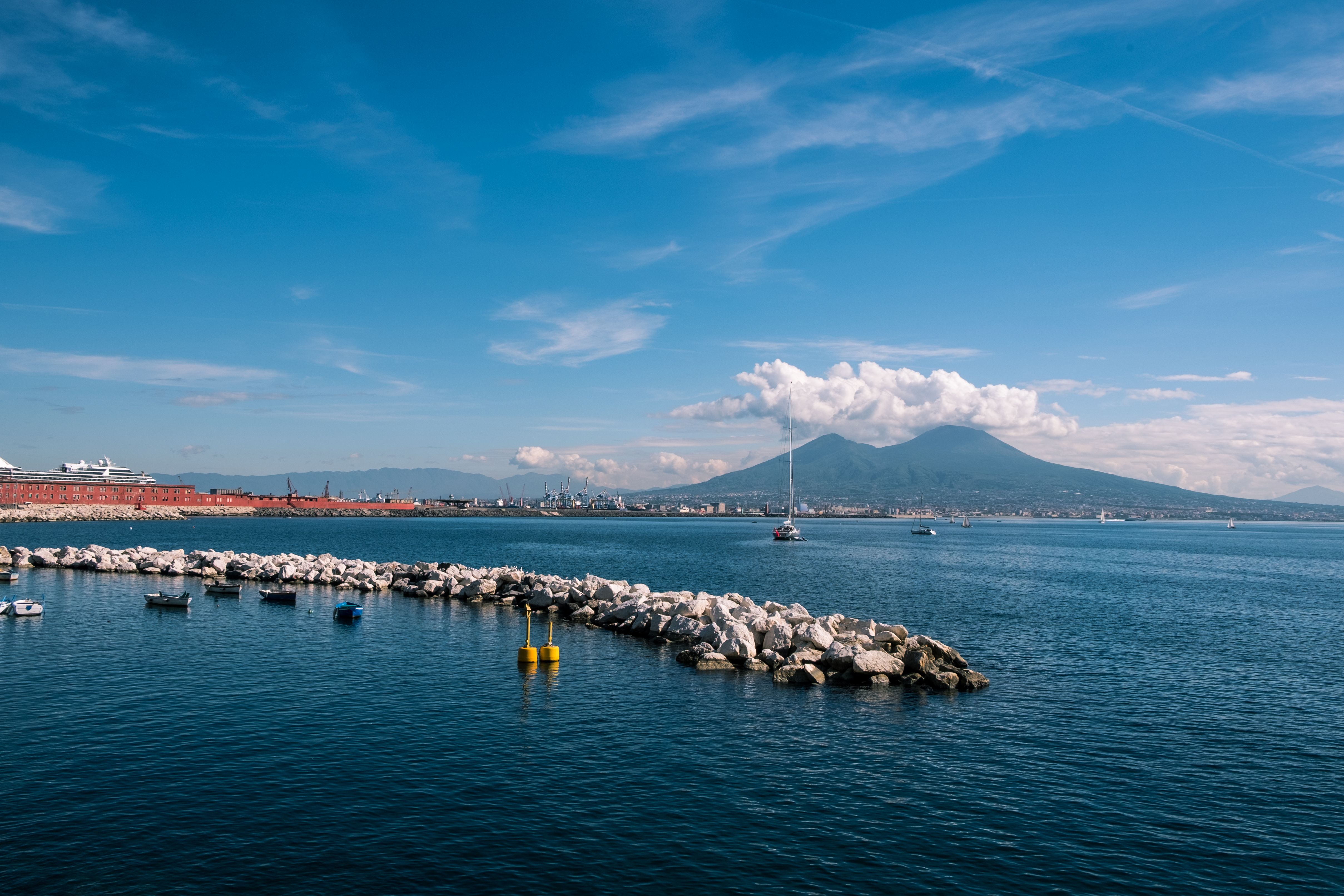 Capture of Mount Vesuvius and the Bay of Naples on a clear day, featuring boats and the harbor.
