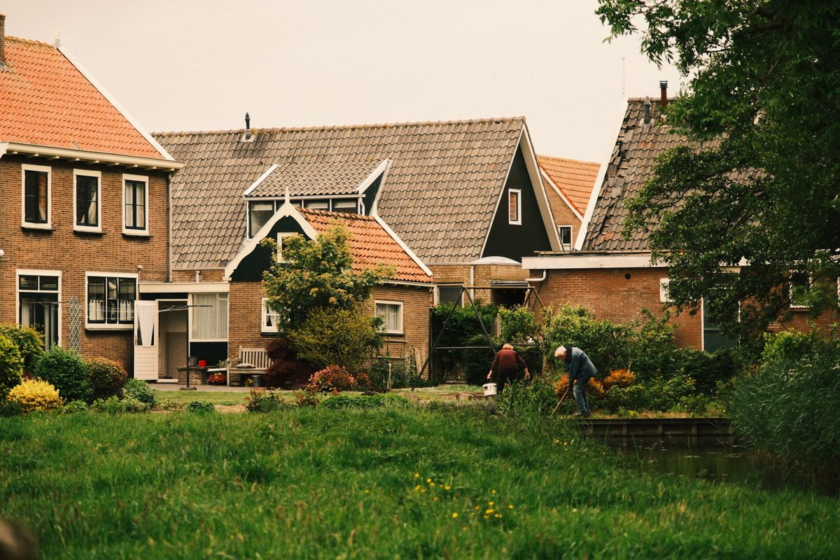 Neighbors working together in a shared community garden beside their homes