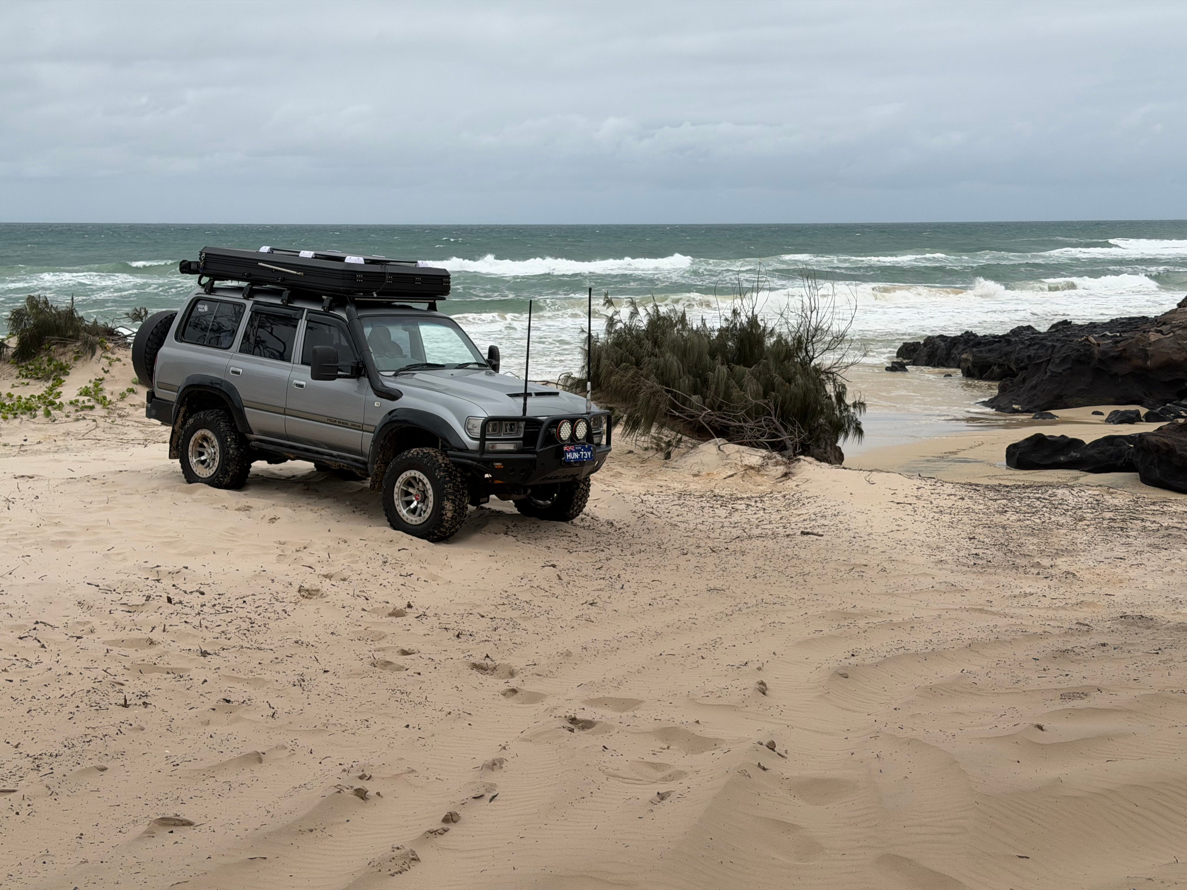 A touring 4WD parked on the beach, the kind of setup where fridge size and access matter as much as the badge on the lid.