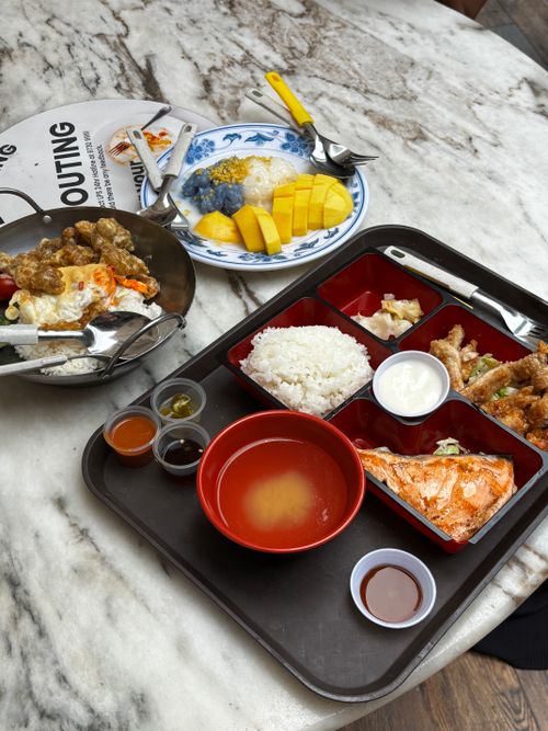 Free A vibrant display of Singaporean seafood and Thai mango sticky rice served on marble table. Stock Photo