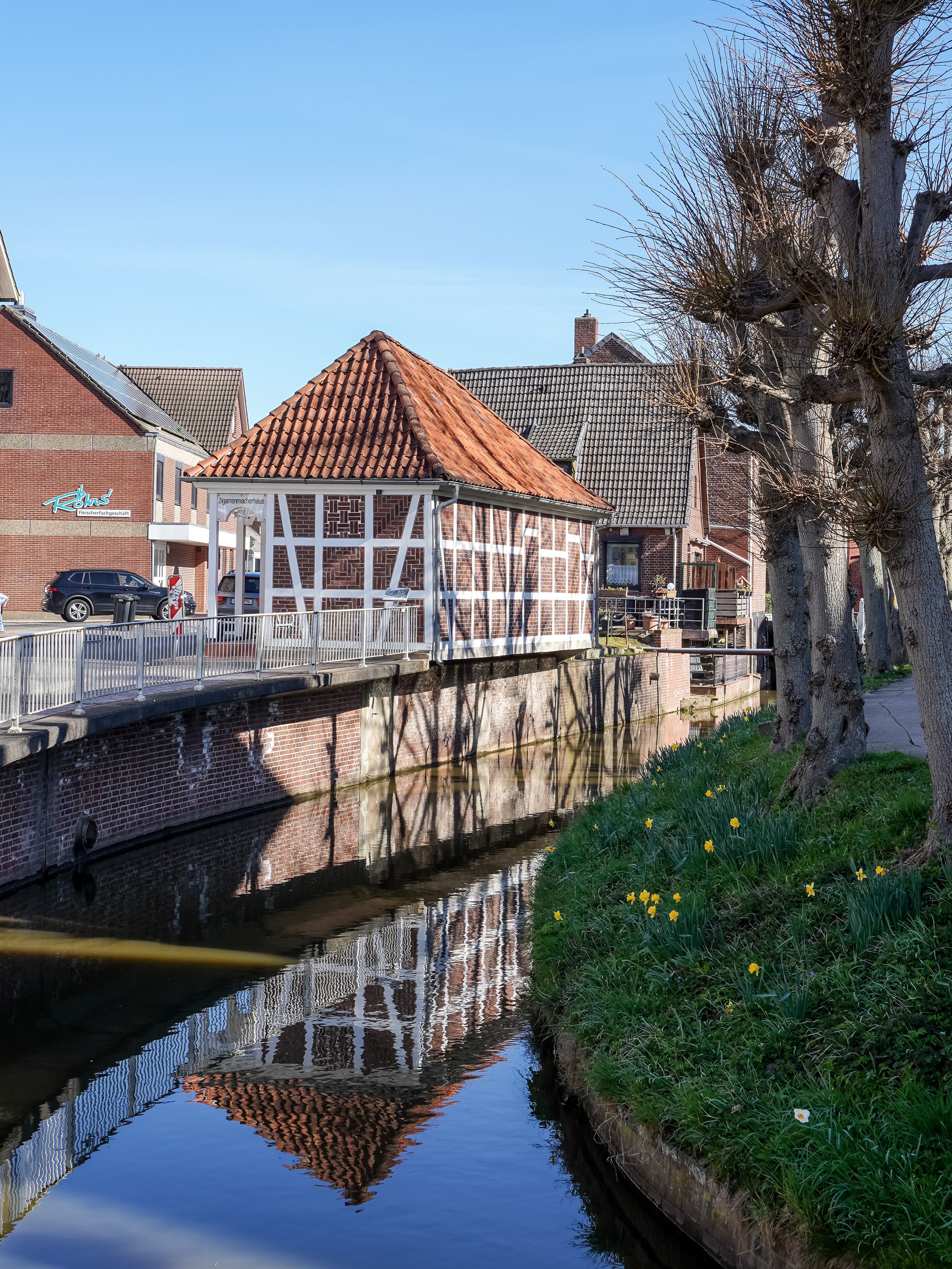 Timbered houses reflecting in a canal in the picturesque village of Jork, Germany.