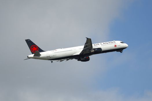 A dramatic shot of an Air Canada Airbus A321 taking off against a cloudy sky in Richmond, Canada.