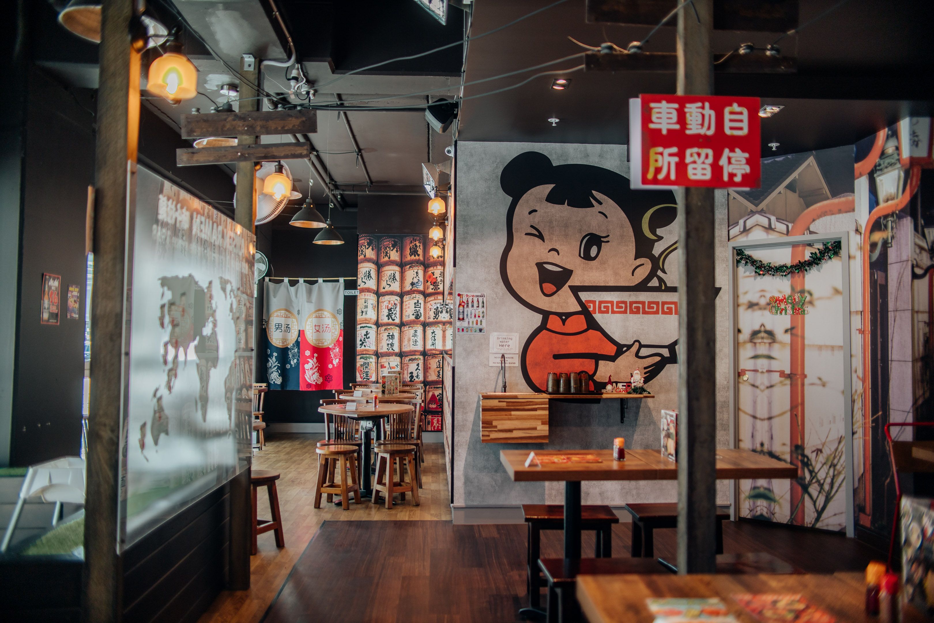 Interior of a Japanese-themed restaurant featuring vibrant wall art and traditional decor.