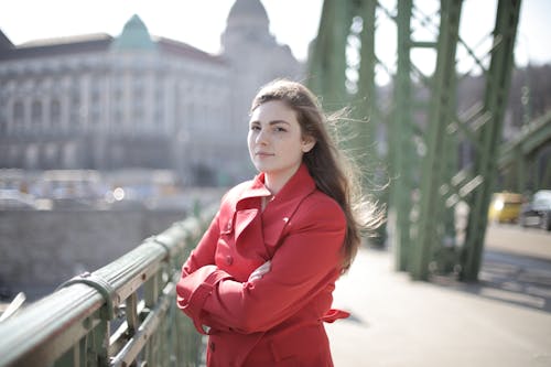 Woman in Red Coat Standing on Bridge