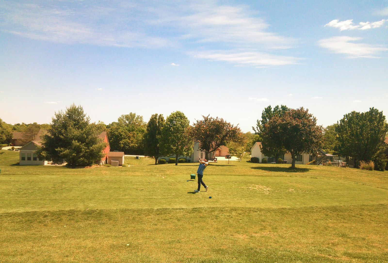 Older adult walking alone along a paved park path in autumn.
