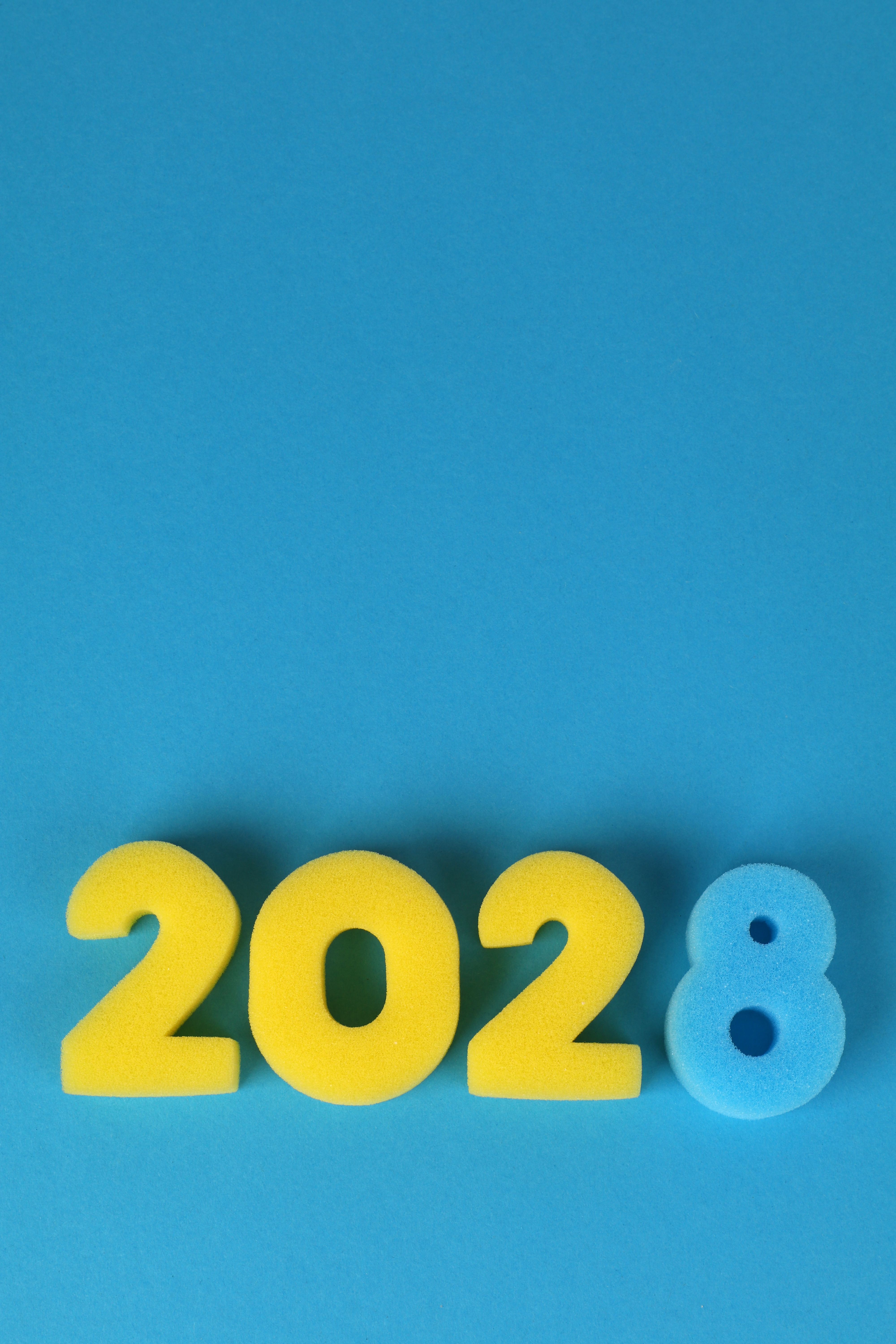 Bright yellow and blue foam numbers forming 2028 against a vibrant blue backdrop.