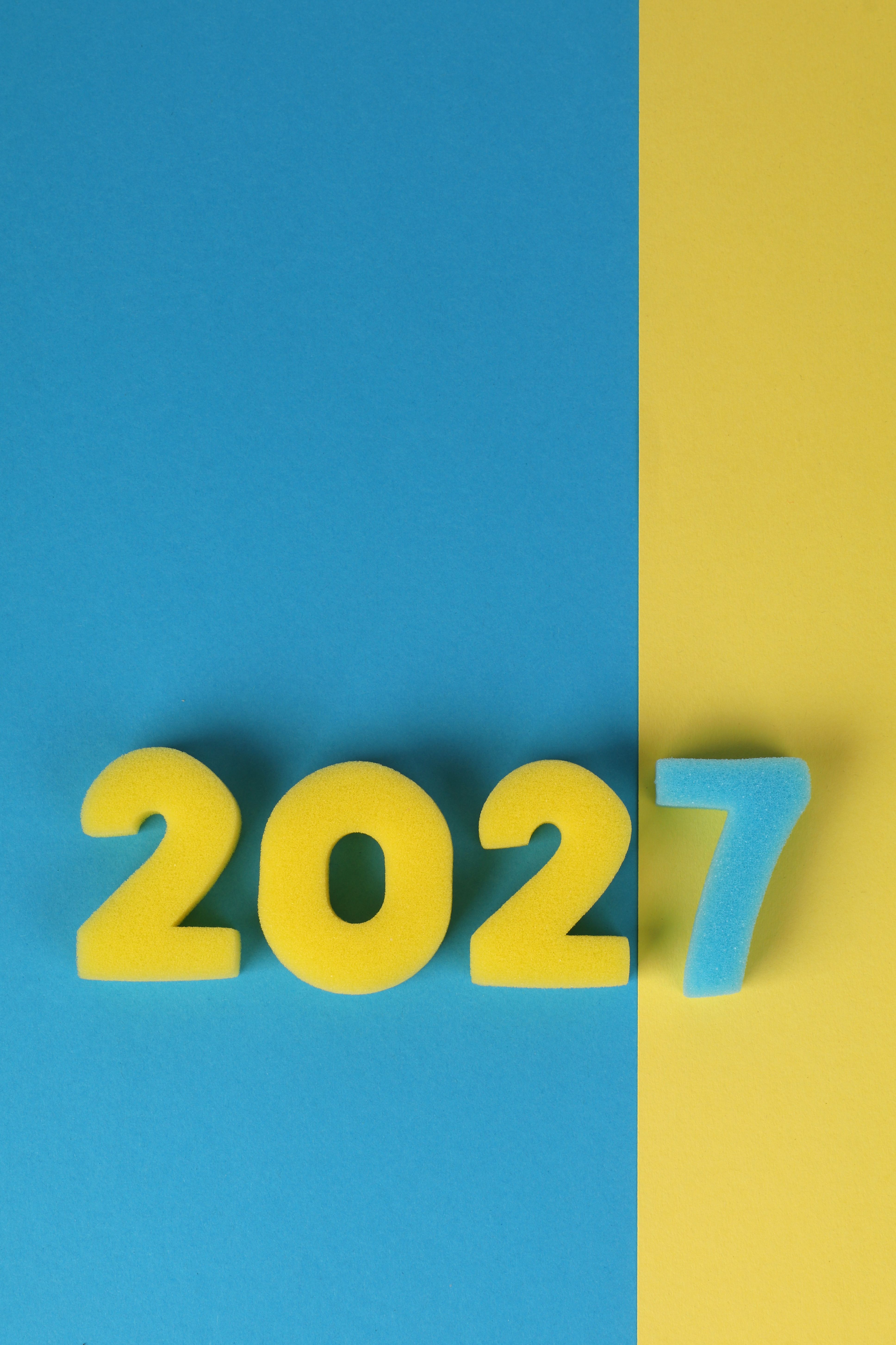Creative numeric display in blue and yellow for New Year 2027 celebration.