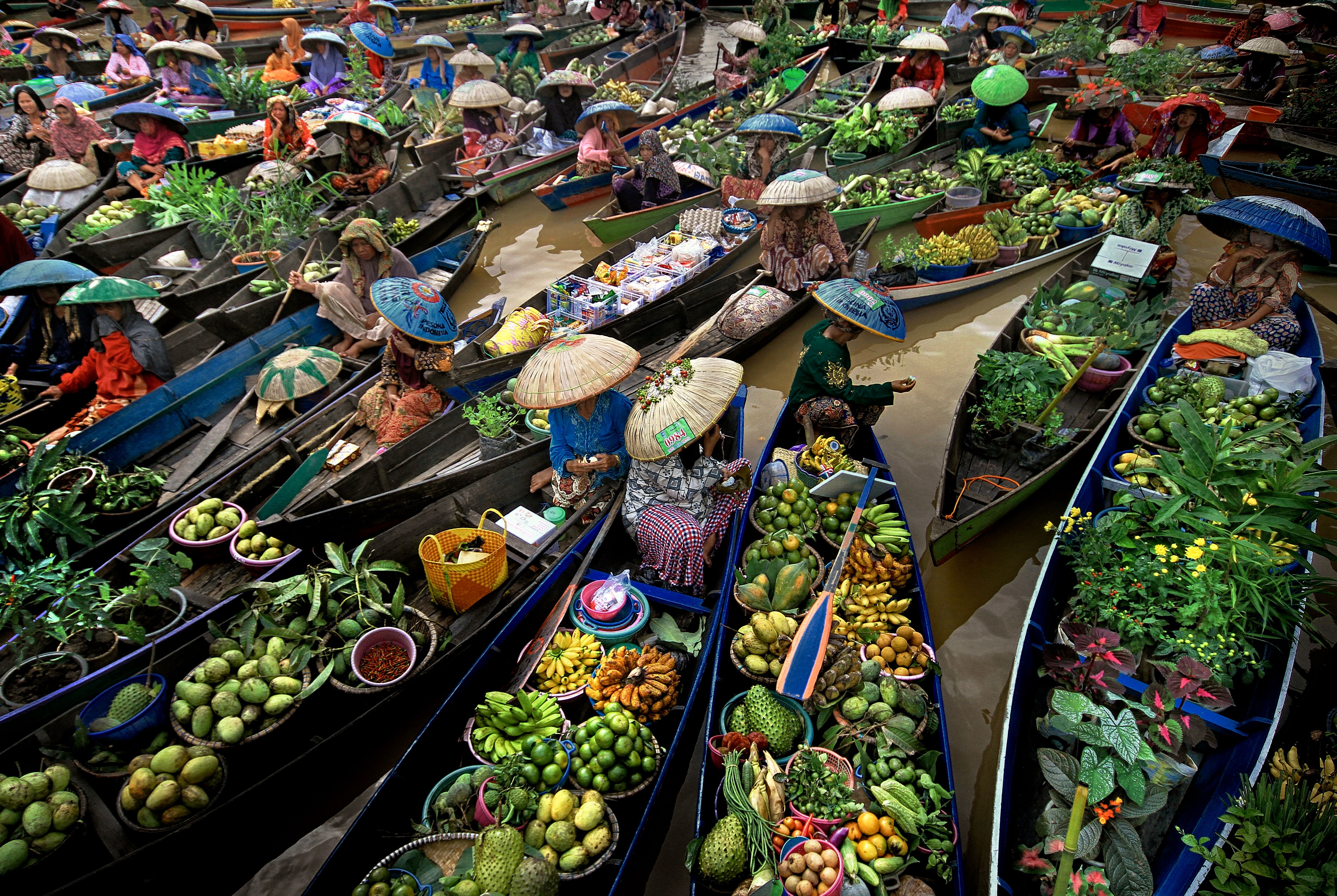 Vibrant boats at an Indonesian floating market selling fresh produce and goods.