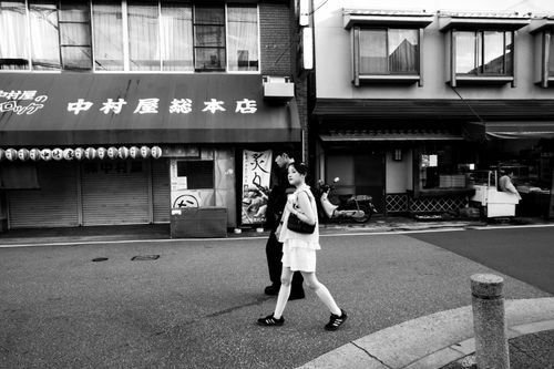 Free A candid black and white photo capturing people walking in a Kyoto street. Urban life in Japan. Stock Photo