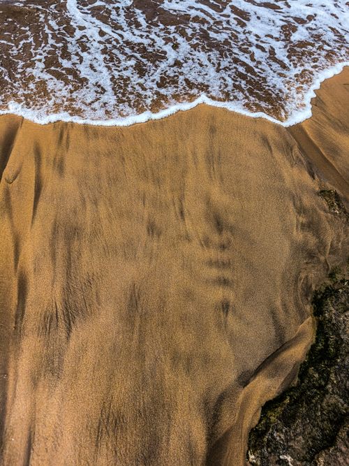 Free Captivating wave patterns on Casablanca's sandy beach, showcasing nature's artistry. Stock Photo