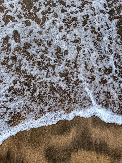 Free Foamy ocean waves gently wash over sandy Casablanca beach during the day. Stock Photo