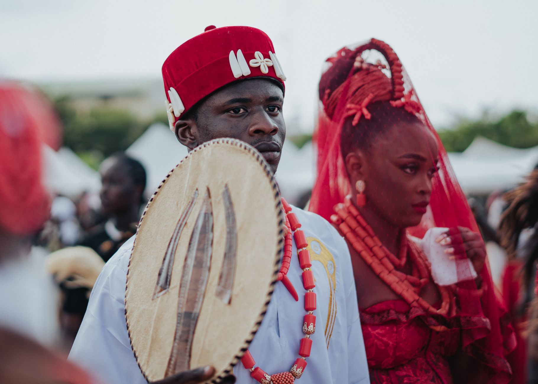 African participants in traditional attire at a cultural festival, showcasing vibrant clothing and ceremonial items.