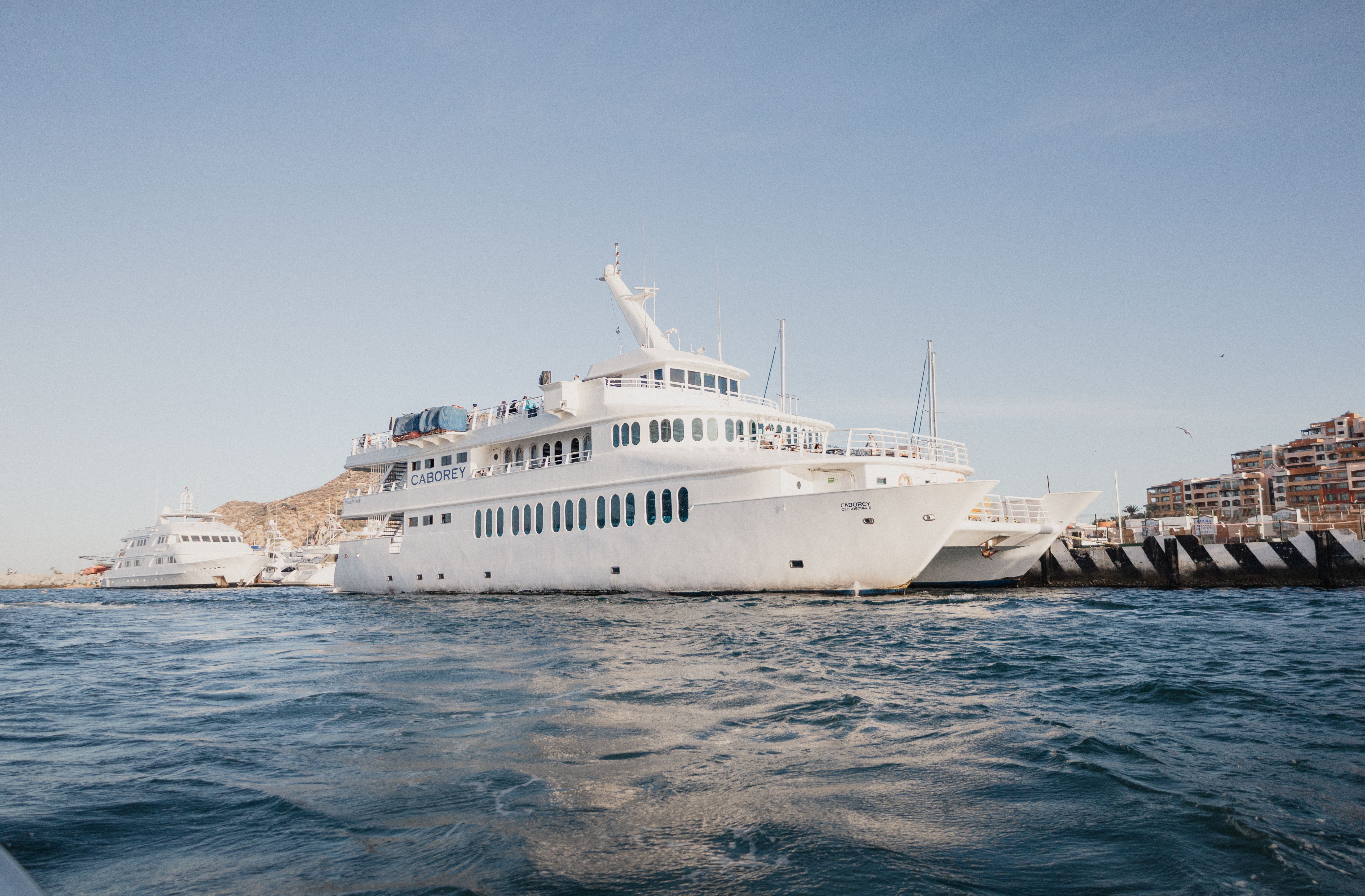 Yate de lujo en la marina de Cabo San Lucas con El Arco al fondo