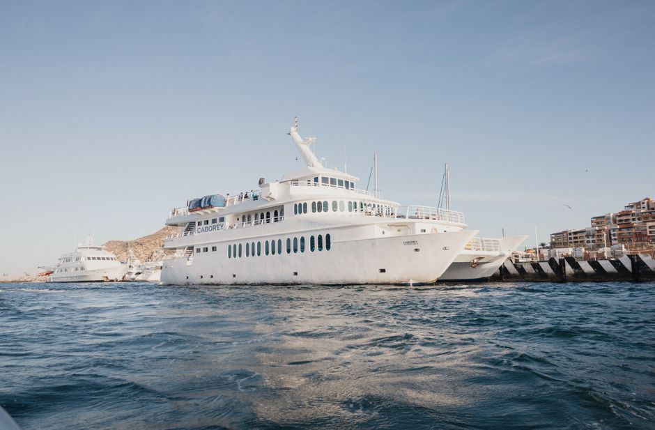 Yate de lujo en la marina de Cabo San Lucas con El Arco al fondo