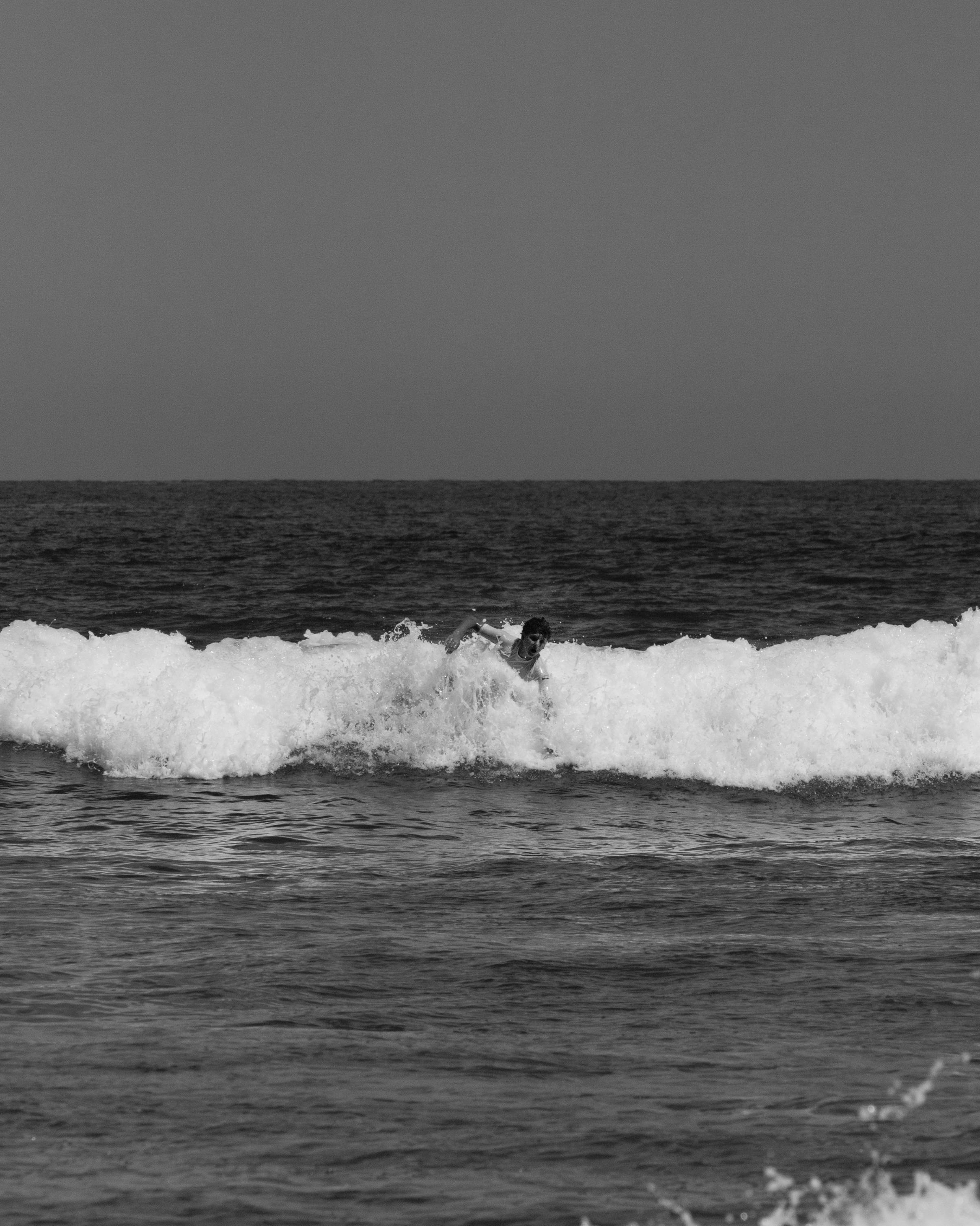 A surfer skillfully rides a wave at Cabo San Lucas, capturing the essence of ocean adventure.