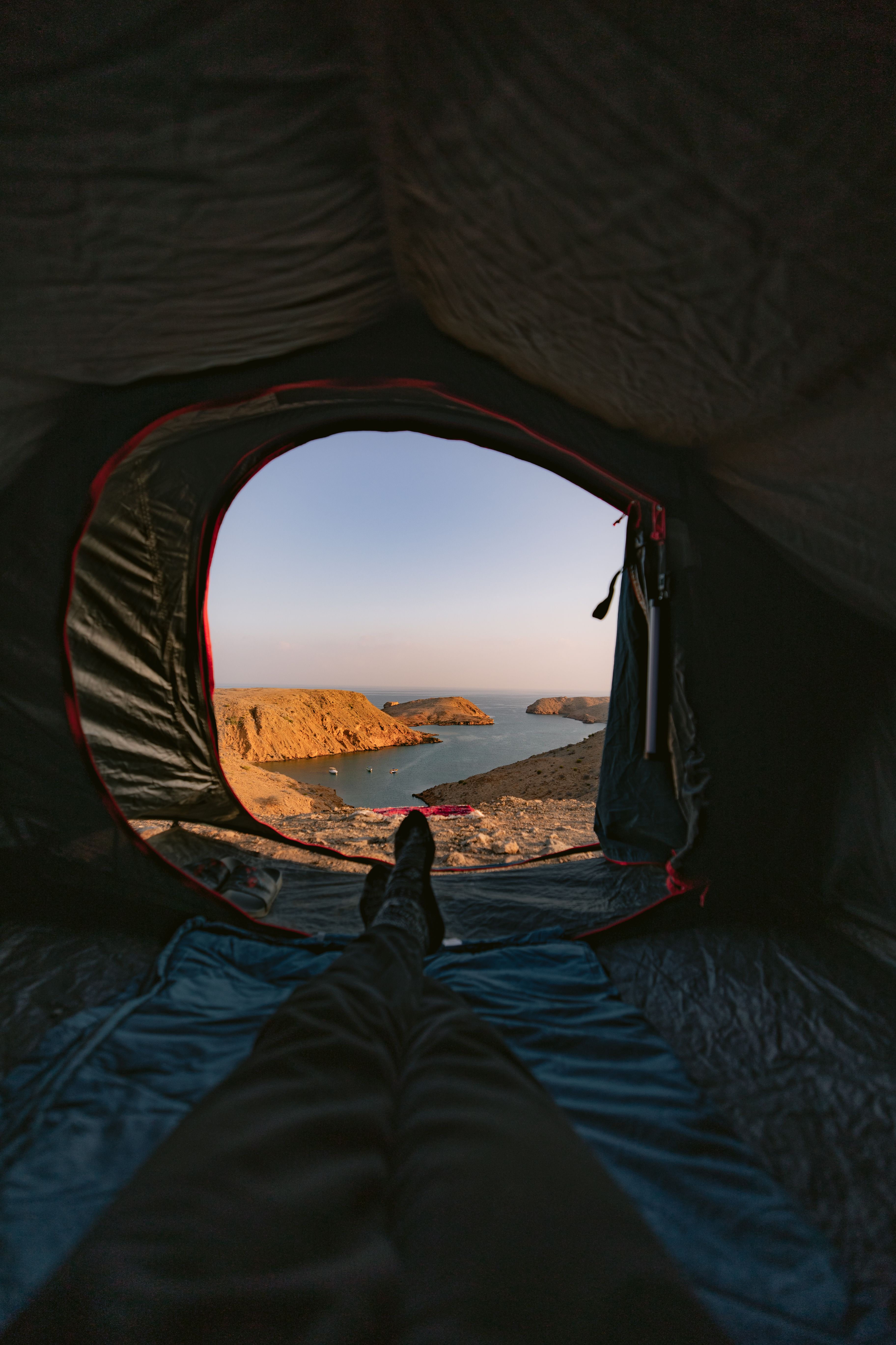 Capture the tranquil view of Muscat's coastline from a cozy tent, perfect for travelers and adventurers.