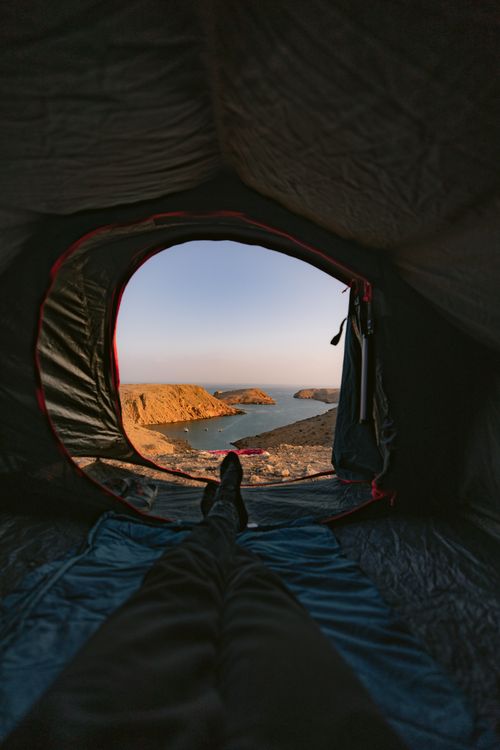 Free Capture the tranquil view of Muscat's coastline from a cozy tent, perfect for travelers and adventurers. Stock Photo