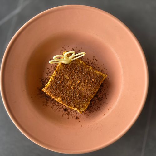 Free Gourmet dessert with chocolate garnish on terracotta plate, perfect for culinary presentations. Stock Photo