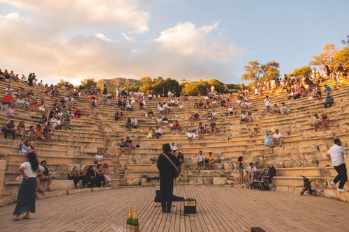 Free A lively outdoor concert at a historic amphitheater during sunset, capturing audience engagement. Stock Photo