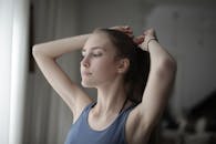 年轻女子在室内柔和的窗户光线下扎头发