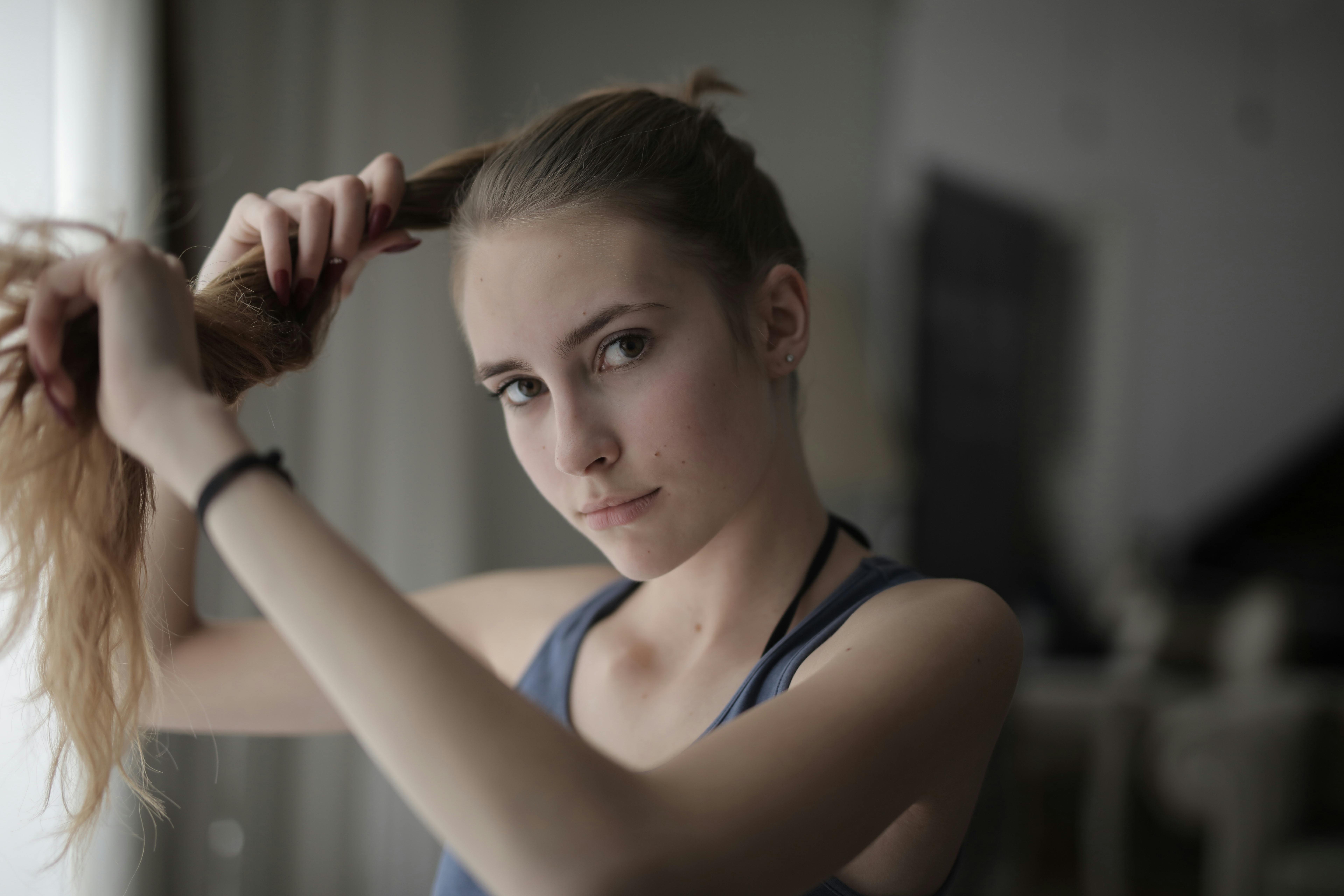 Woman in Blue Tank Top While Holding Her Hair · Free Stock Photo