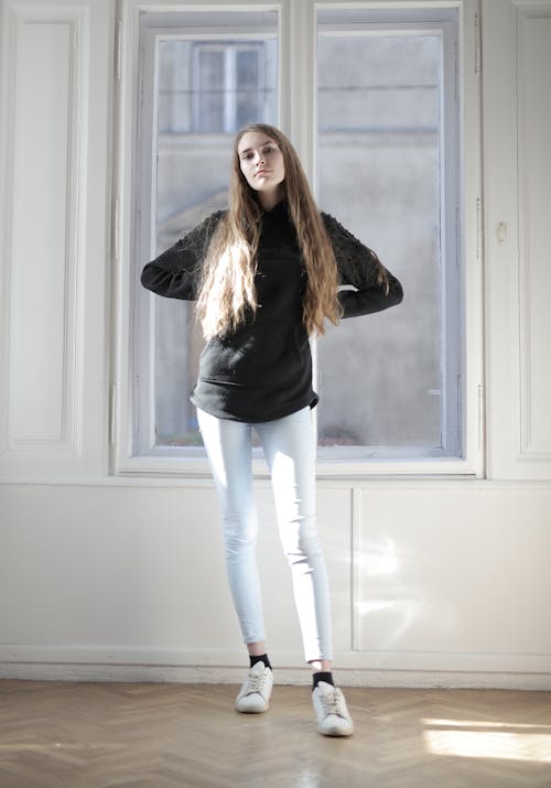 Woman in Black Long Sleeve Shirt and White Denim Jeans