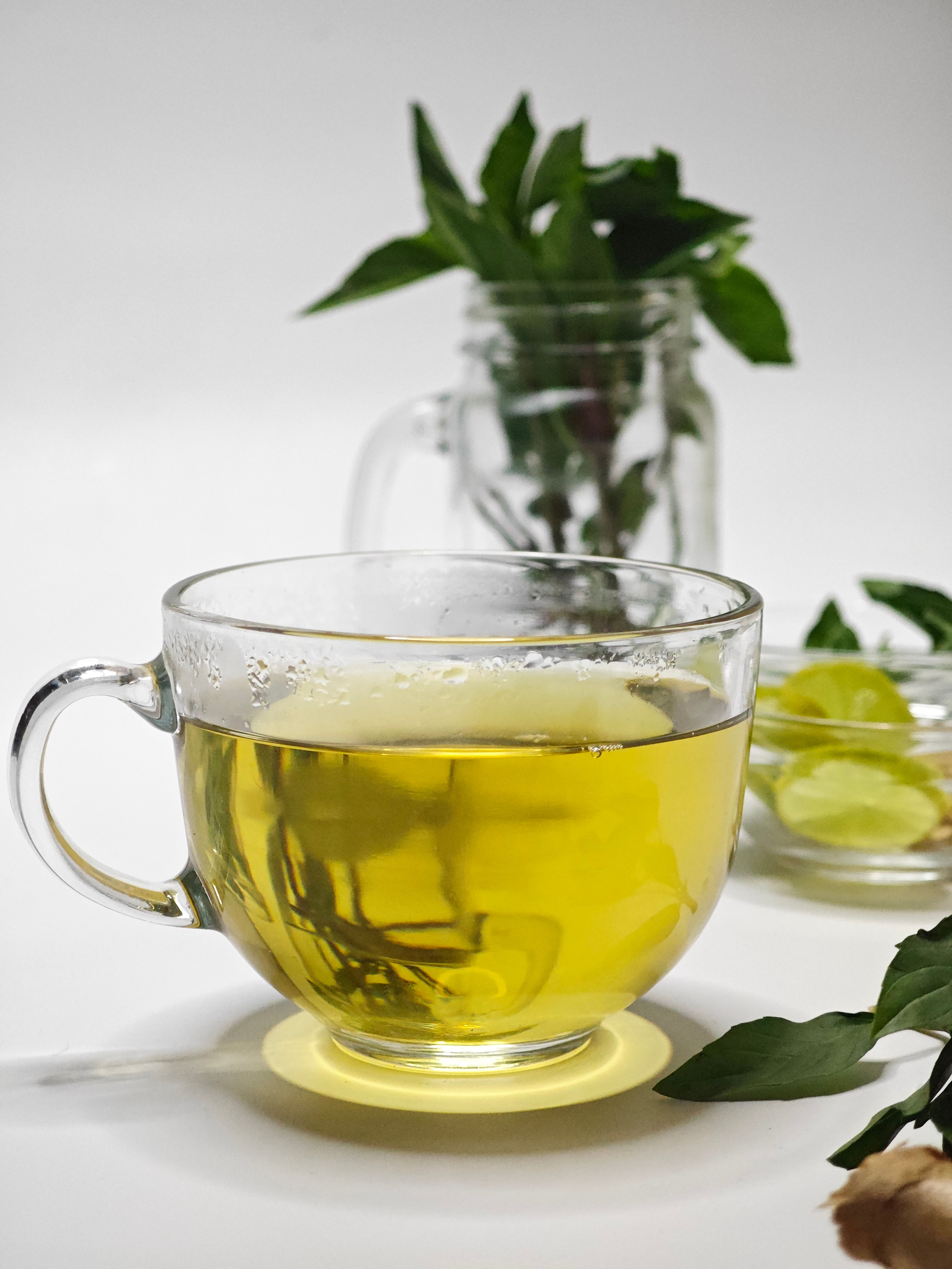 A clear glass cup of herbal tea with fresh mint and lime, exuding a refreshing vibe.