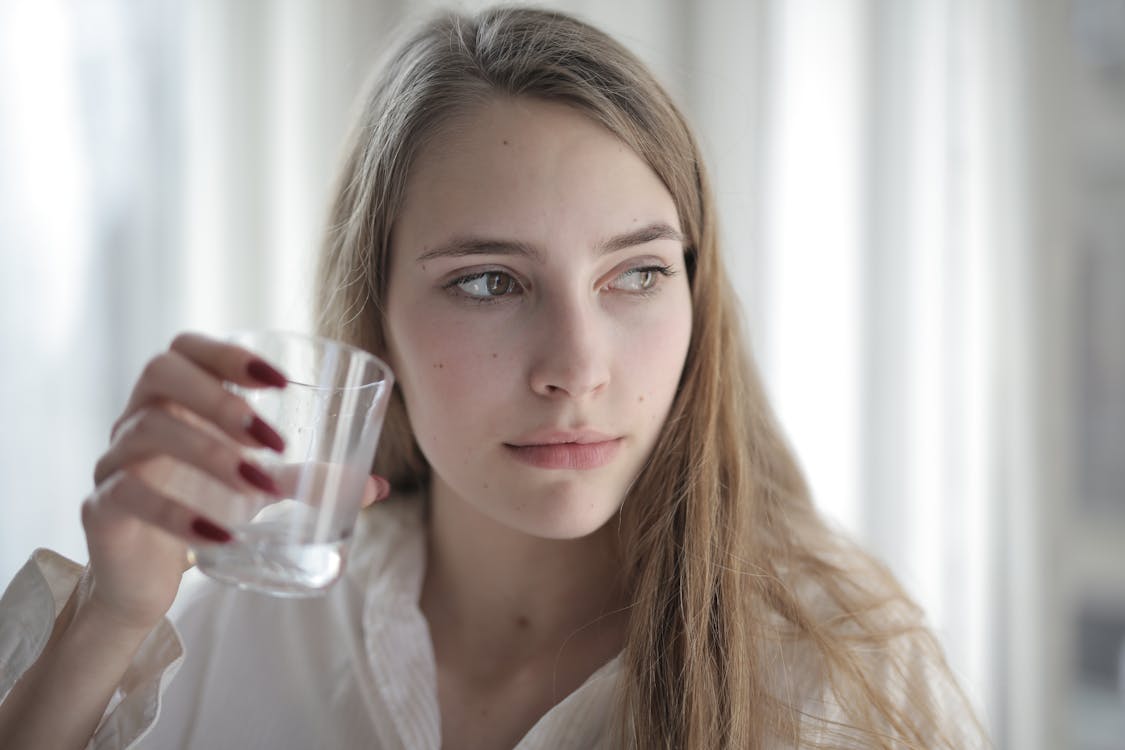 Woman in White Shirt Holding Drinking Glass