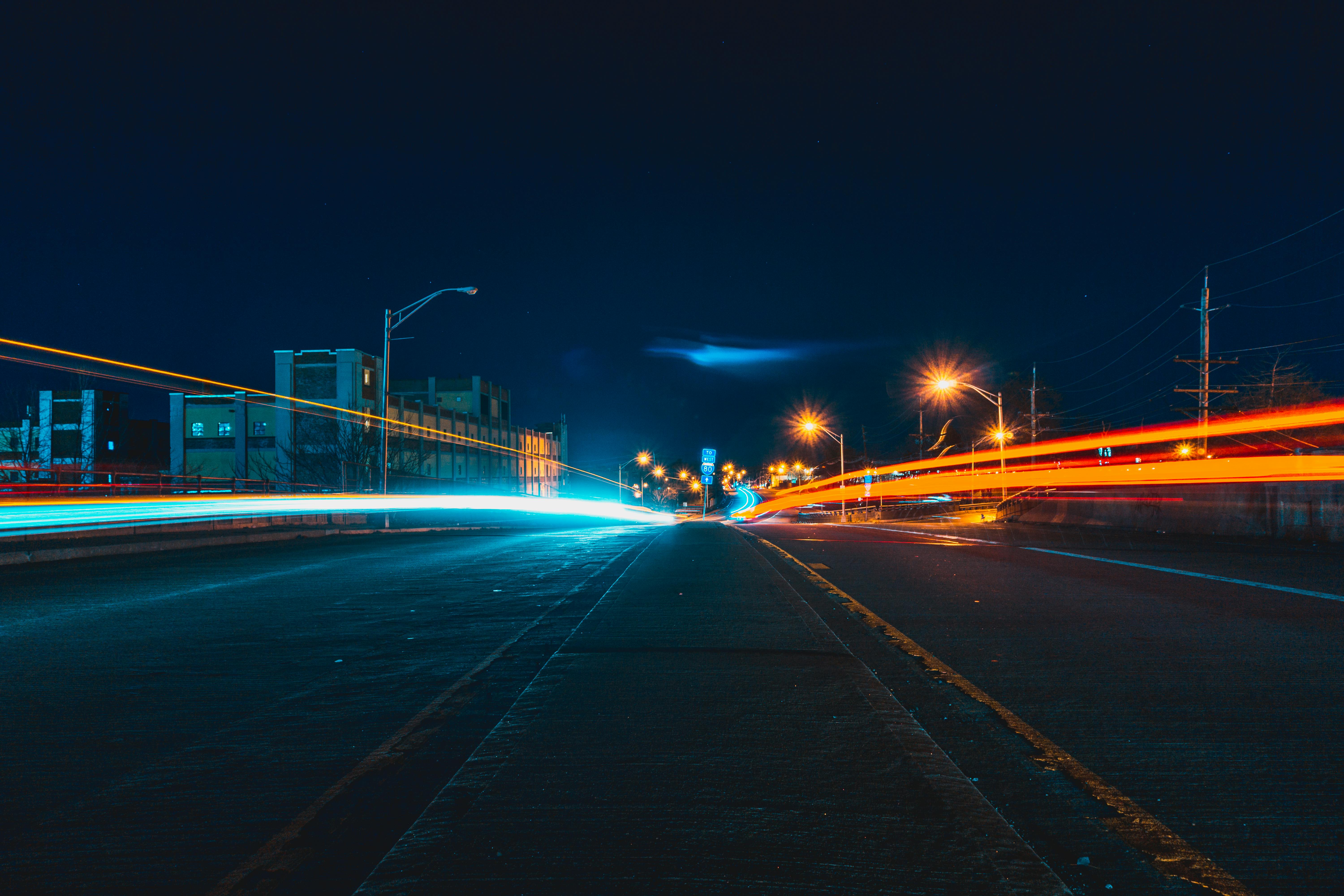 time lapse photo of light painting of cards on the streets