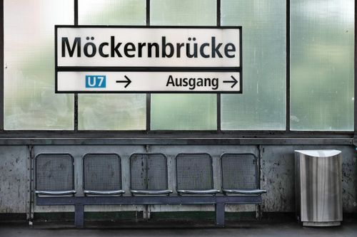 Free A view of Möckernbrücke U7 station sign in Berlin with seating and clean design. Stock Photo