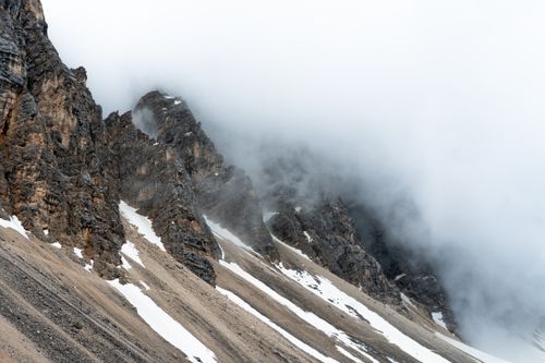 Free Dramatic, mist-covered peaks of the Dolomites showcasing nature's raw beauty in Veneto, Italy. Stock Photo