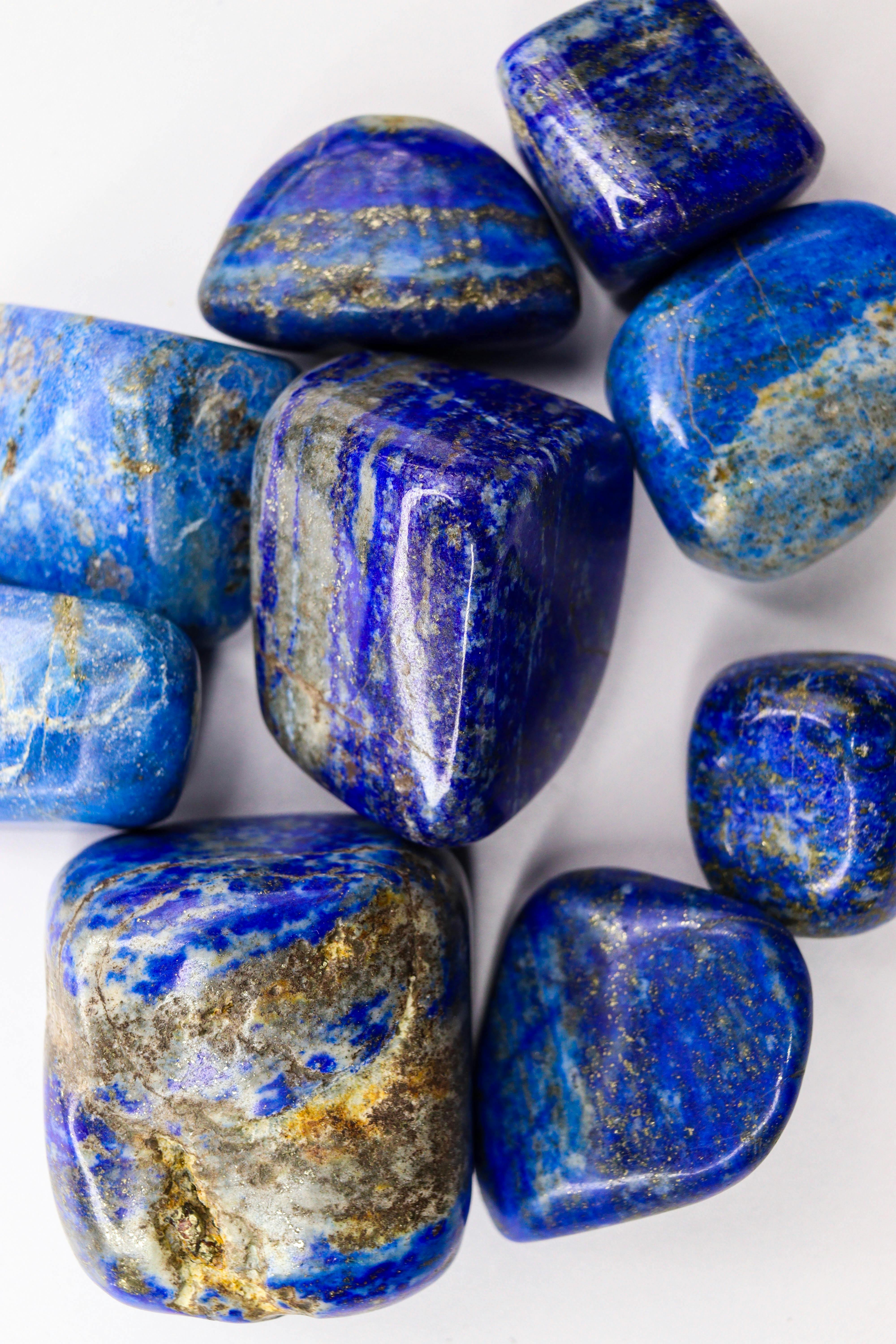 Collection of polished lapis lazuli stones showcasing vibrant blue hues and unique patterns.