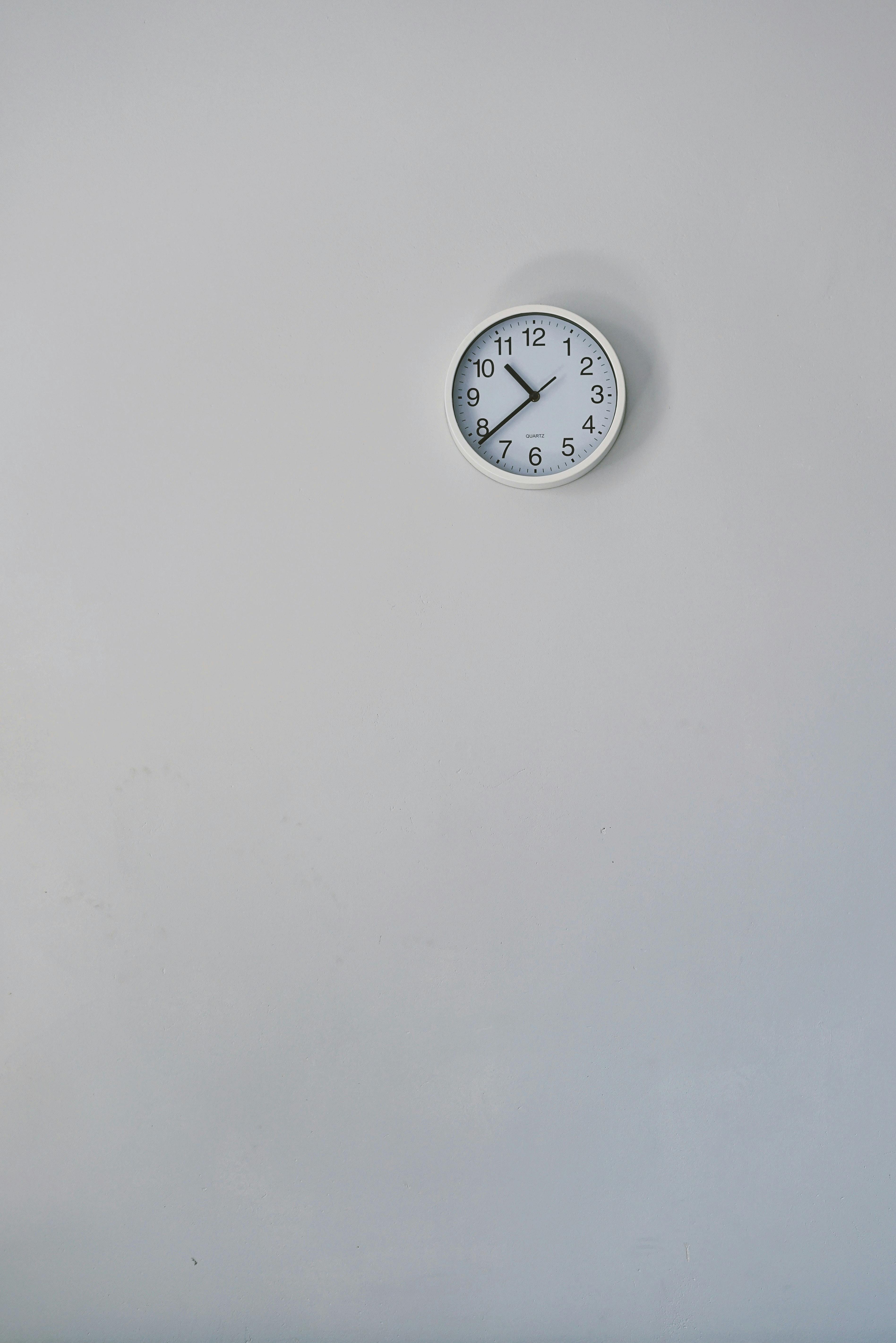 silver round wall clock mounted on wall