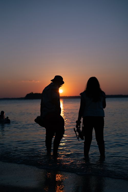 Free Silhouette of a couple enjoying a romantic sunset at Wandoor Beach, Andaman Islands. Stock Photo