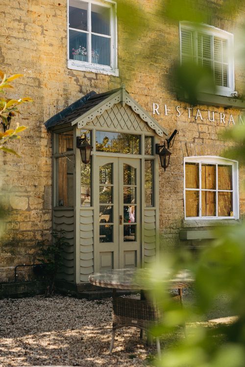 Free Charming entrance of a traditional English restaurant framed by greenery in summer. Stock Photo