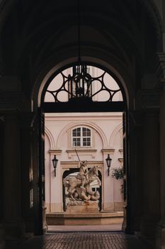 View through an archway of a historic statue in the Baroque architecture of Bratislava, Slovakia.