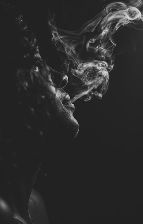 Grayscale Photo of Woman Smoking