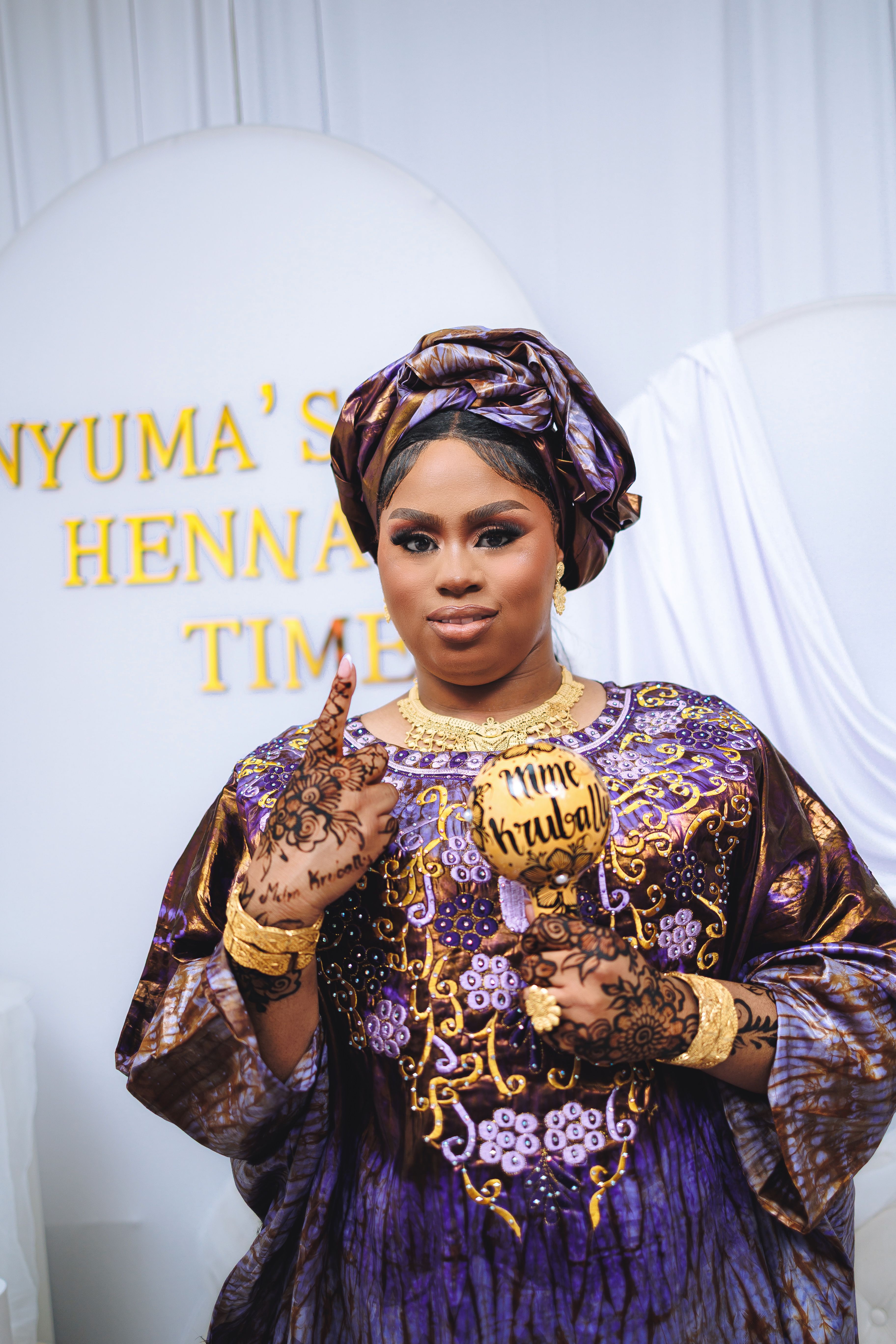 Woman in traditional attire at a henna ceremony with decorative elements.