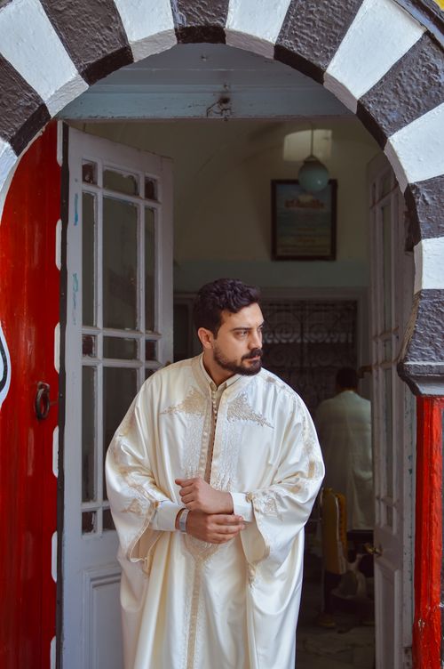 Free Man in traditional clothing standing in a Tunisian medina doorway. Stock Photo