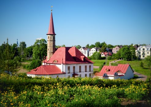 View of Priory Palace surrounded by greenery and flowers in Gatchina, Russia.