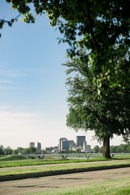 Free A scenic view of Dayton's skyline framed by lush trees on a sunny day. Stock Photo