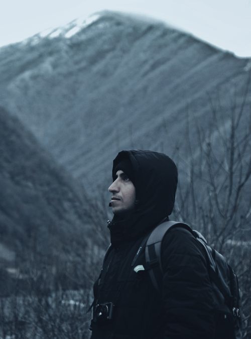 Free Man hiking in winter mountain terrain, embracing solitude and adventure. Stock Photo