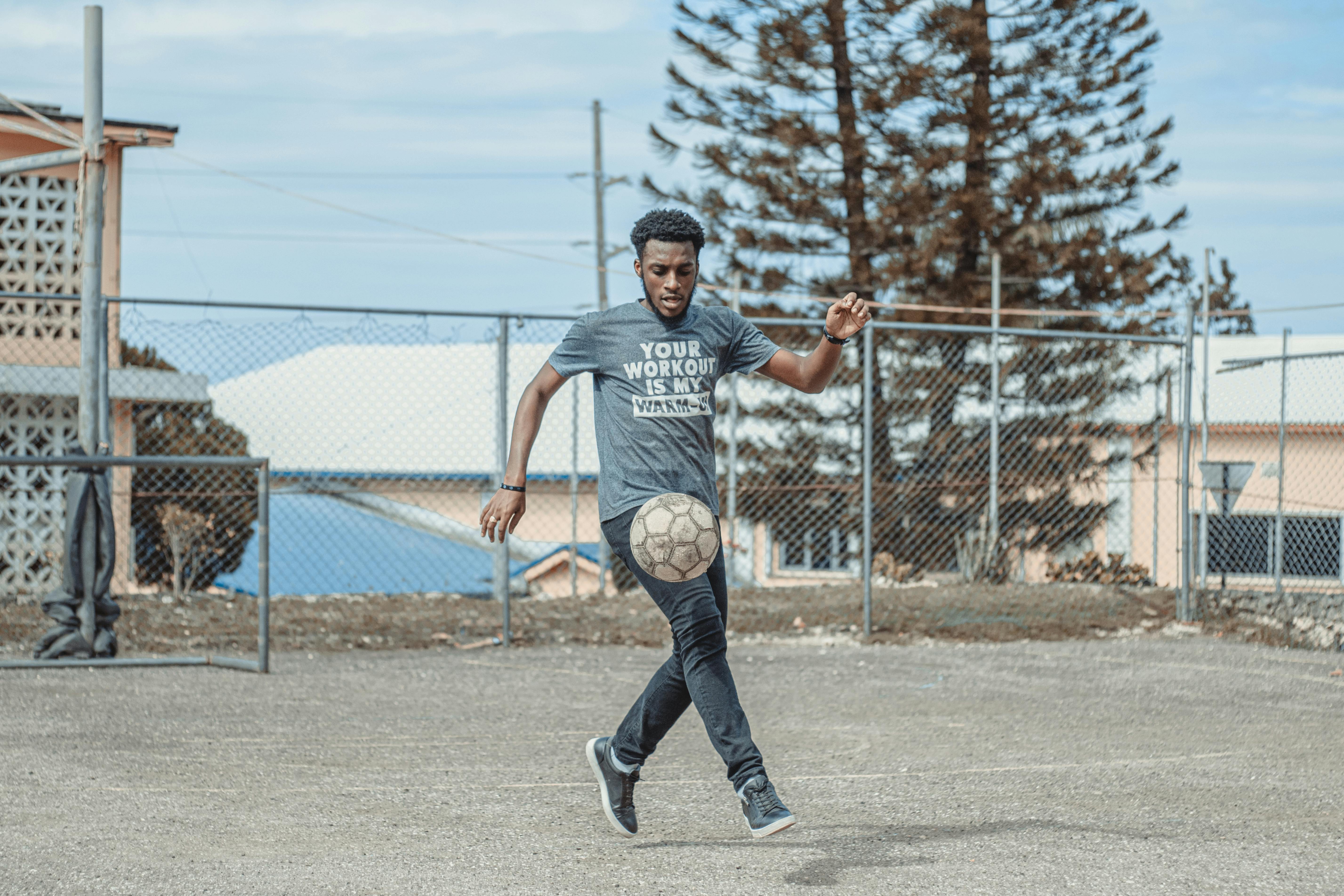 man in gray crew neck t shirt and black pants playing basketball